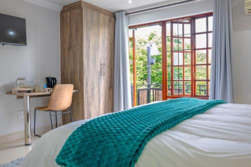 a bedroom with a bed with a green blanket on it at Apple Blossom Hotel Portfolio in Roodepoort