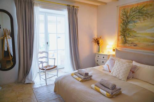 a bedroom with a bed with towels on it at Plates Luxury Farm House Chambres d'hôtes et gîte in Saint-Mézard