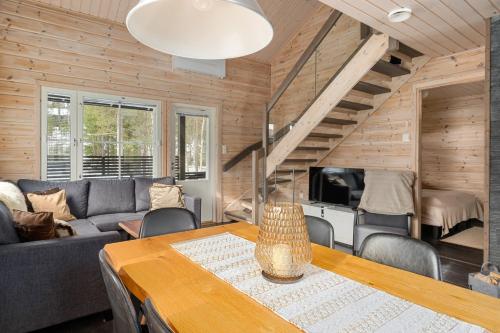 a living room with a table and a couch at Skicamp 3 - Modern 3BR Villa in Pyhätunturi in Pyhätunturi