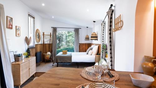 a bedroom with a bed and a table in a room at Le Pavillon - Les Lodges de Praly in Les Ollières-sur-Eyrieux