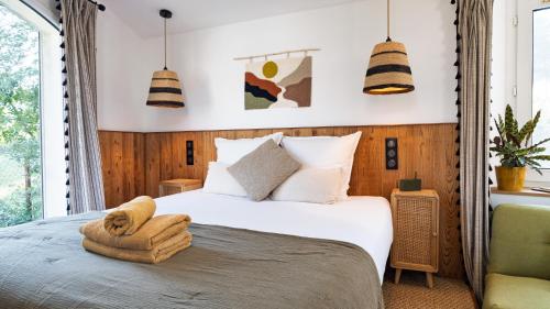 a bedroom with a bed with a towel on it at Le Pavillon - Les Lodges de Praly in Les Ollières-sur-Eyrieux
