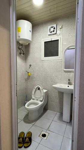 a small bathroom with a toilet and a sink at RUBA apartment in Dammam