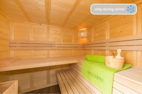 a wooden sauna with a green bench in it at Hinterbichlhof - Apartments in Viehhofen
