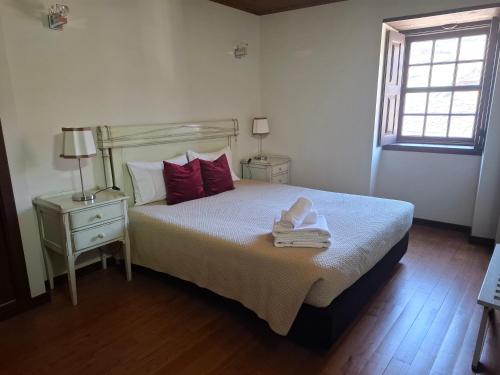 a bedroom with a bed with towels on it at Casa do Lello in Bragança
