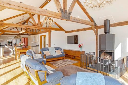 a living room with wooden ceilings and a fireplace at Amber Lodge in Ashover