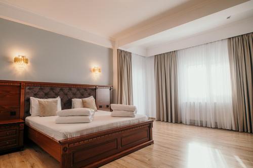 a bedroom with a large bed with white sheets at Hotel Restaurant Elite in Drobeta-Turnu Severin