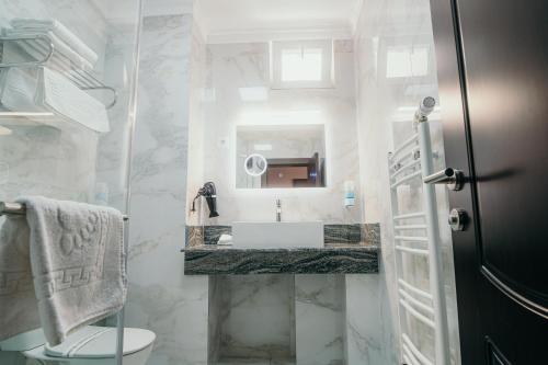 a bathroom with a sink and a toilet and a mirror at Hotel Restaurant Elite in Drobeta-Turnu Severin