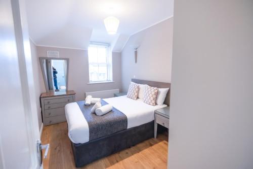 a small bedroom with a bed and a mirror at Alensgrove Cottages #2 in Leixlip