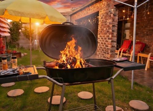 a large pot on a grill with a fire at Romaic Guesthouse Welkom in Welkom