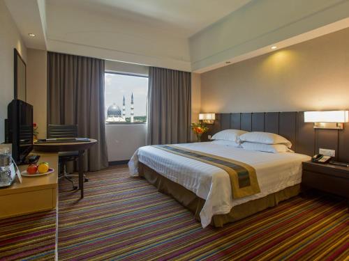 سرير أو أسرّة في غرفة في فندق كونكورد شاه علم