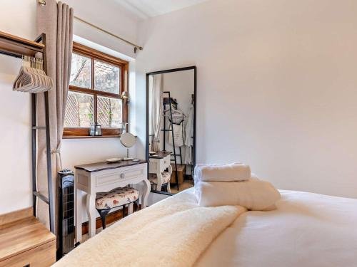 a white bedroom with a bed and a mirror at 1 Bed in Thirsk oc-94728 in Thirsk