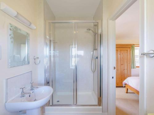 a white bathroom with a shower and a sink at 3 Bed in Consett oc-cn195 in Hunstanworth