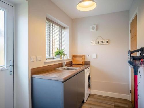 a kitchen with a sink and a washing machine at 3 Bed in Seahouses oc-81486 in Seahouses