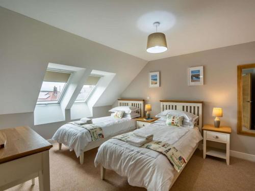 a bedroom with two beds and a window at 3 Bed in Seahouses oc-81486 in Seahouses