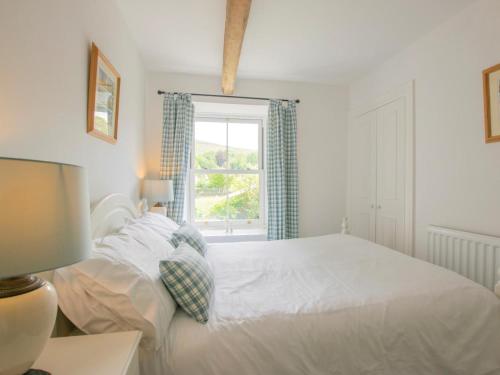 a bedroom with a white bed and a window at 2 Bed in Leyburn oc-75441 in West Burton