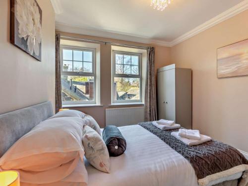 a bedroom with a large bed and two windows at 1 Bed in Alnwick oc-94380 in Embleton