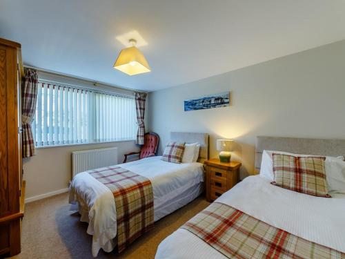 a bedroom with two beds and a window at 3 Bed in Wooler oc-93544 in Wooler