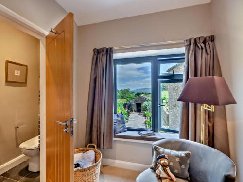 a living room with a window and a chair and a toilet at 3 Bed in Leyburn oc-76395 in Askrigg