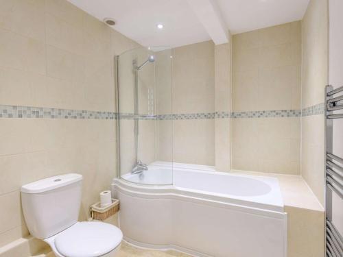 a bathroom with a toilet and a tub and a sink at 2 Bed in Swanage oc-dc068 in Langton Matravers
