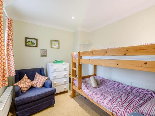 a bedroom with a bunk bed and a chair at 2 Bed in Swanage oc-dc068 in Langton Matravers