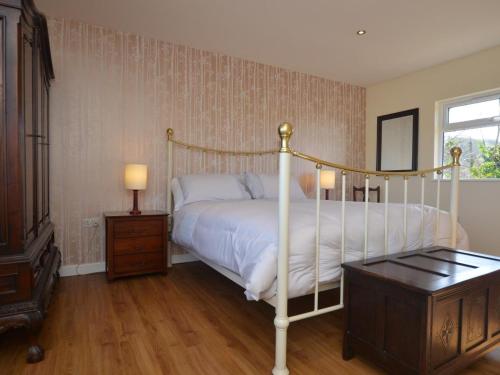 a bedroom with a white bed and a wooden floor at 2 Bed in Kewstoke oc-57144 in Weston-super-Mare