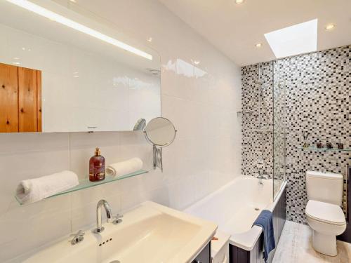 a bathroom with a sink and a toilet and a mirror at 3 Bed in Beadnell oc-cn037 in Beadnell