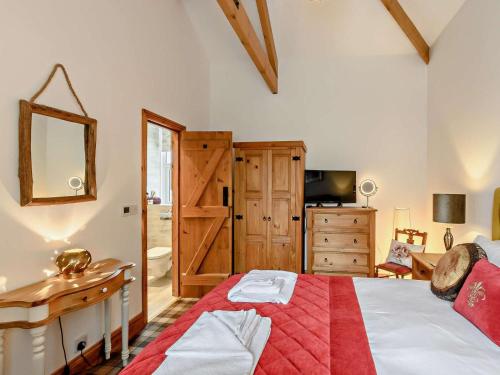 a bedroom with a bed and a desk and a mirror at 3 Bed in Beadnell oc-cn037 in Beadnell
