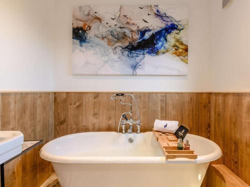 a bathroom with a white tub and a painting on the wall at 2 Bed in Leyburn oc-91102 in Finghall