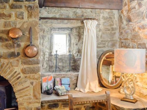 a stone room with a table with a lamp and a mirror at 2 Bed in Bishop Auckland oc-93111 in Westgate