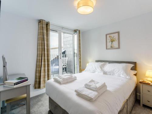 a bedroom with a bed with white sheets and a window at 1 Bed in Brockenhurst oc-78730 in Brockenhurst