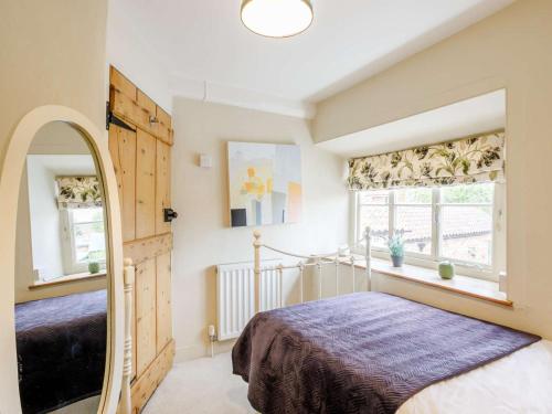 a bedroom with a bed and a mirror at 3 Bed in Helmsley oc-82891 in Helmsley