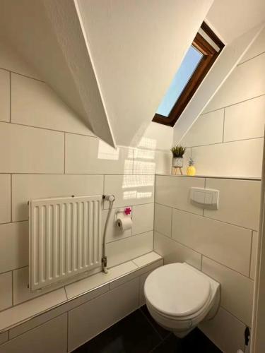 a white bathroom with a toilet and a window at Schönes Zimmer im Zentrum - 2 in Paderborn