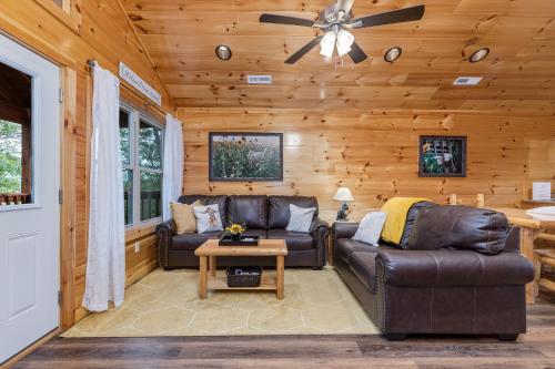 a living room with two leather couches and a ceiling fan at Prime Location & Loaded For Family Fun in Pigeon Forge