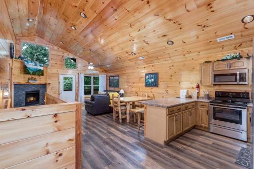 a kitchen and living room of a log cabin at Prime Location & Loaded For Family Fun in Pigeon Forge