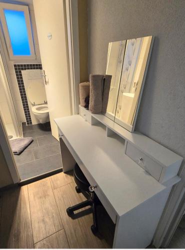 a white bathroom with a sink and a toilet at Le Petit Beurre de cacahuète et Le Poivre et Sel in Fully