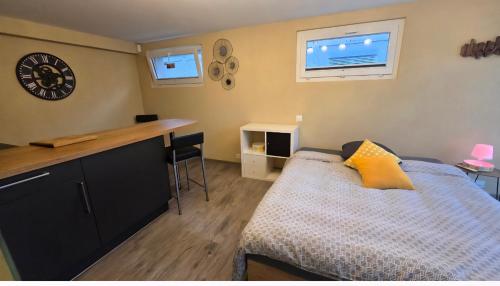 a small bedroom with a bed and a desk at Le Petit Beurre de cacahuète et Le Poivre et Sel in Fully