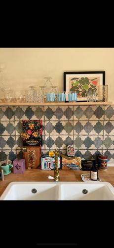 a kitchen with a sink and a tiled wall at Südfrankreich bei Berlin in Werder