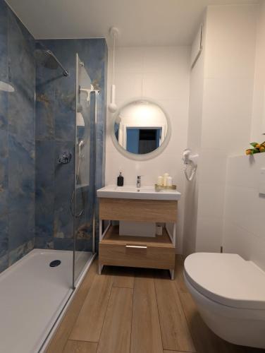 a bathroom with a sink and a toilet and a mirror at BelMare 327 Aqua in Międzyzdroje