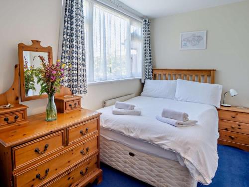 a bedroom with a bed with a dresser and a mirror at 4 Bed in Shanklin oc-ic068 in Shanklin