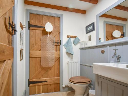 a bathroom with a wooden door and a toilet at 2 Bed in Berwick -upon- Tweed oc-36344 in Kyloe