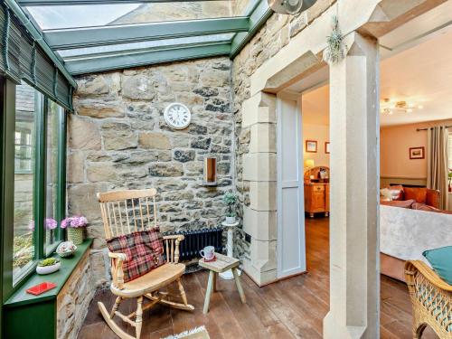 a room with a stone wall and a rocking chair at 3 Bed in Backworth oc-cn011 in Backworth