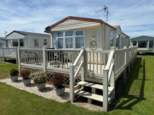 a small house with a porch and some plants at Luxury Caravan Coastfields Holiday Village in Ingoldmells