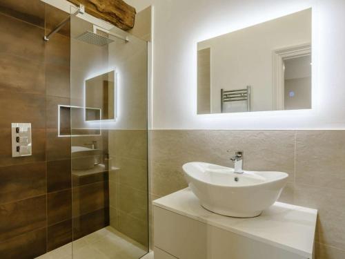 a bathroom with a sink and a shower with a mirror at 3 Bed in Skipton oc-84014 in Rylstone