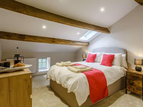 a bedroom with a large bed with red pillows at 3 Bed in Skipton oc-84014 in Rylstone