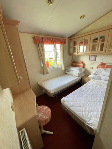 a small room with two beds and a window at Luxury Caravan Coastfields Holiday Village in Ingoldmells