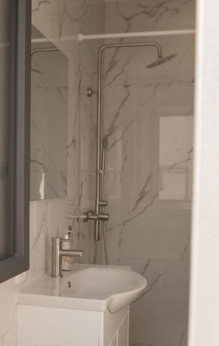 a white bathroom with a sink and a mirror at Haus Auf Bulz - Klippeneck in Denkingen