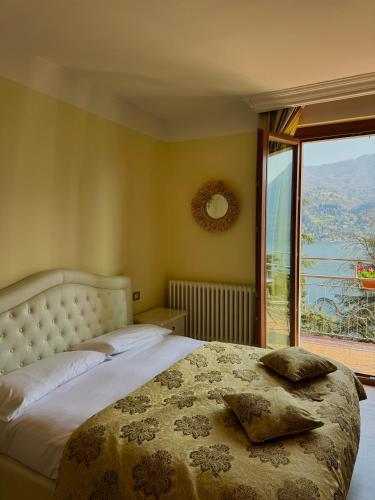 a bedroom with a large bed and a large window at Hotel San Marino in Laglio