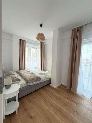 a bedroom with a bed and a table and a window at Arya Thermalis in Baile Felix