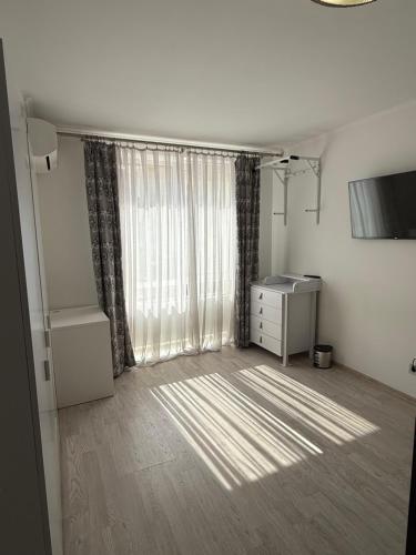 a room with a window with a dresser and a desk at Apartments Chaiky Kyiv in Chayky