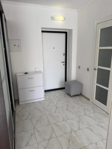 a white room with a door and a tiled floor at Apartments Chaiky Kyiv in Chayky
